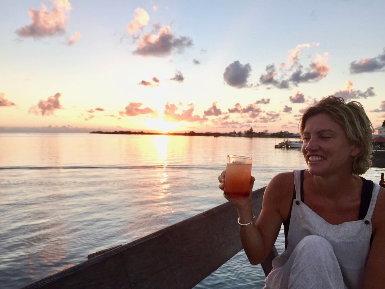 Tania sipping a tequila sunrise at sunset in utila